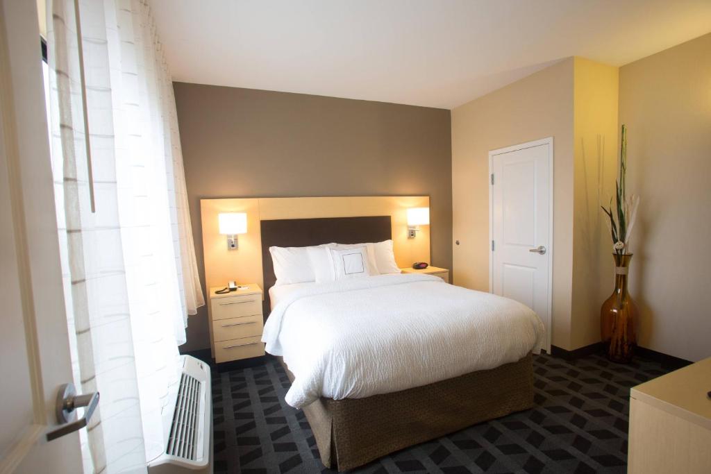 een slaapkamer met een groot wit bed en een raam bij TownePlace Suites by Marriott Lincoln North in Lincoln