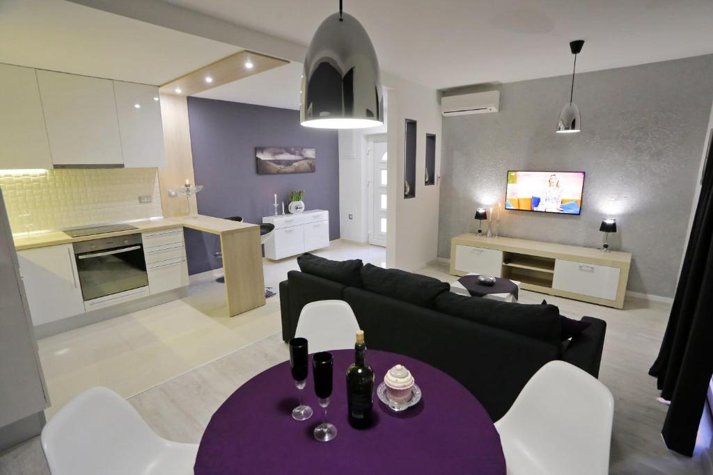 a living room with a black couch and a purple table at Sfinga apartment in Zadar