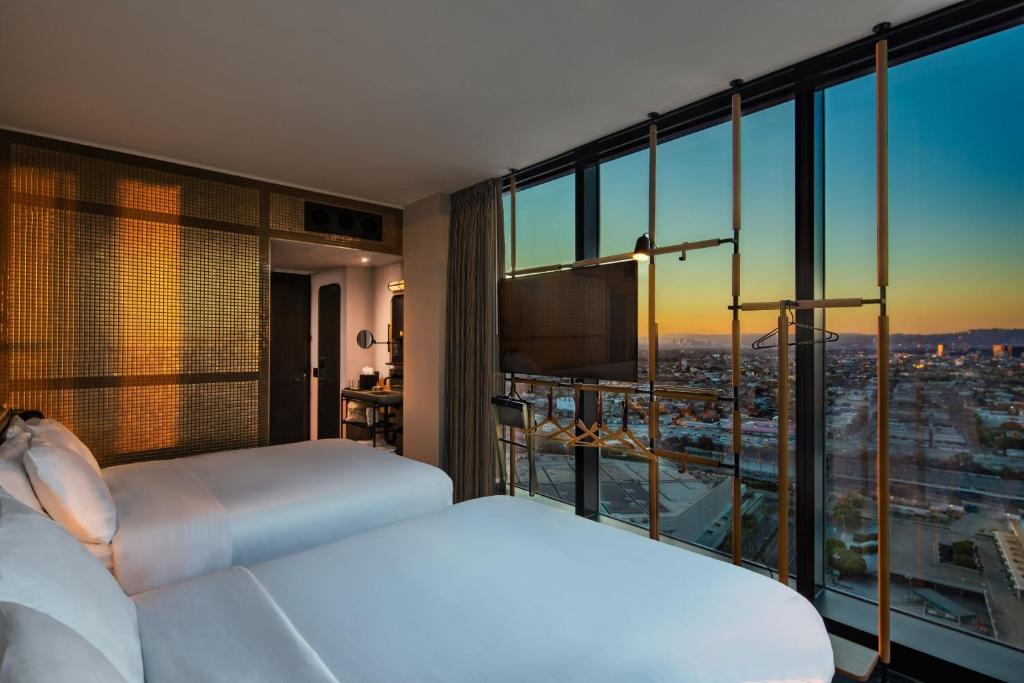 two beds in a hotel room with a view at Moxy Downtown Los Angeles in Los Angeles