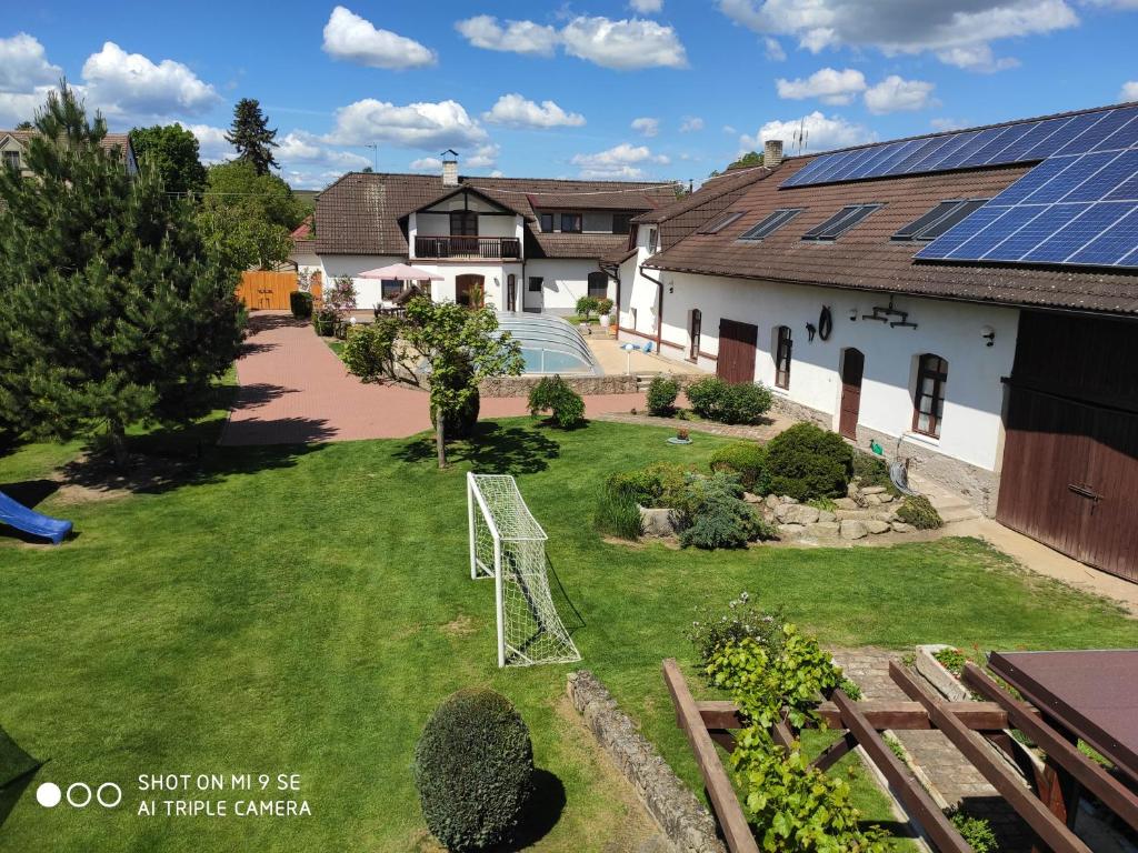 une image d'une maison avec des panneaux solaires sur la cour dans l'établissement Apartmány Močovice, 