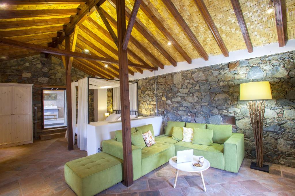 a living room with a green couch and a stone wall at Lyhnos in Askas