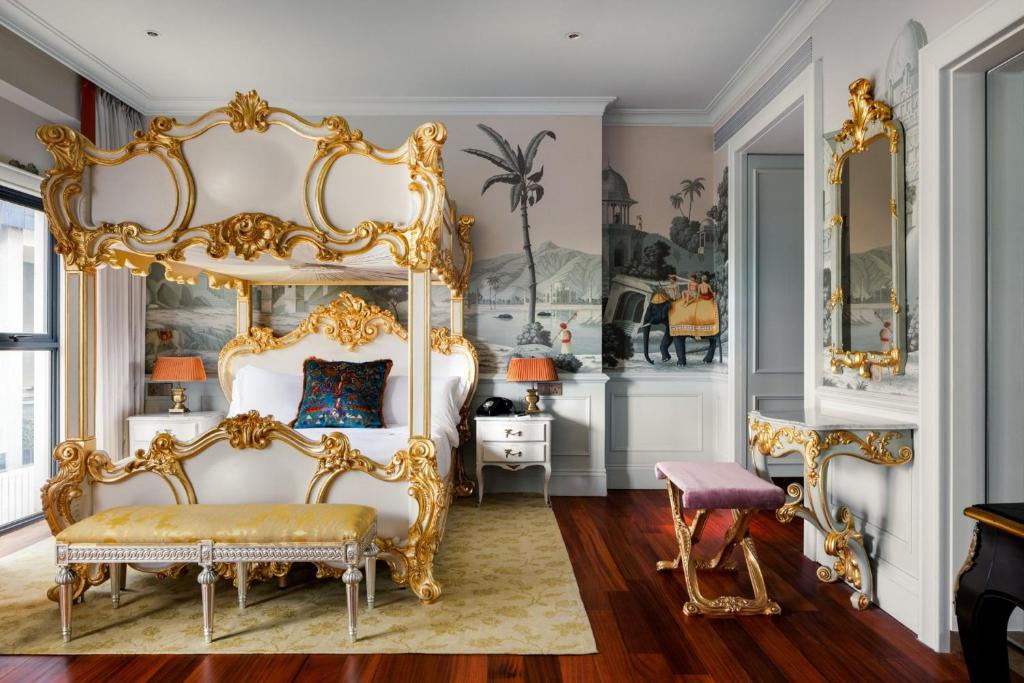 an ornate bedroom with a gold canopy bed at The Serangoon House, Singapore, a Tribute Portfolio Hotel in Singapore