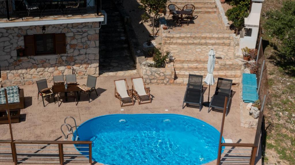 an overhead view of a swimming pool with chairs and a table at Zante Xigia Bay villas in Khartáta