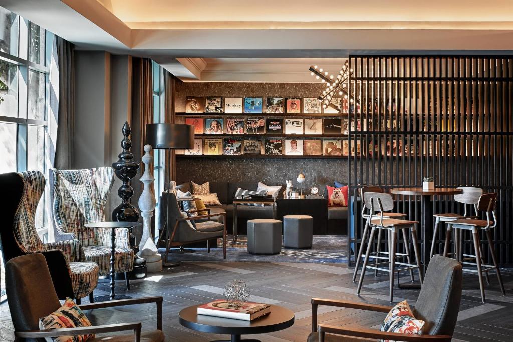 a lobby with chairs and tables and a bar at Renaissance Los Angeles Airport Hotel in Los Angeles