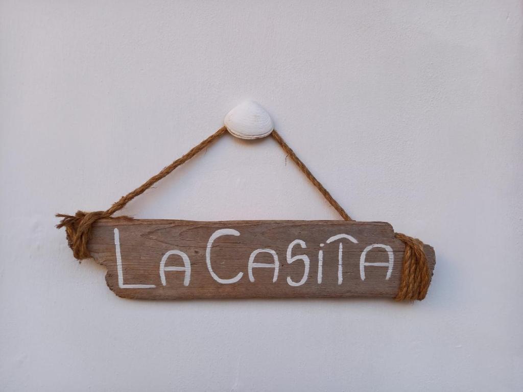 een bord waarop staat: la casita hangt aan een muur bij "La Casita", 2 Floors Apartment, Private Parking 1 car OR 2 Bikes, Air-Cond and Terrace in Livorno