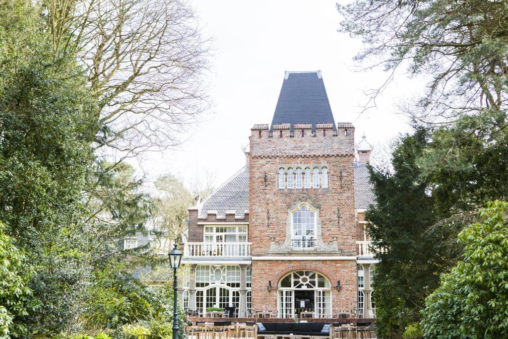 a large brick building with a tower on top of it at Kasteel Kerckebosch in Zeist