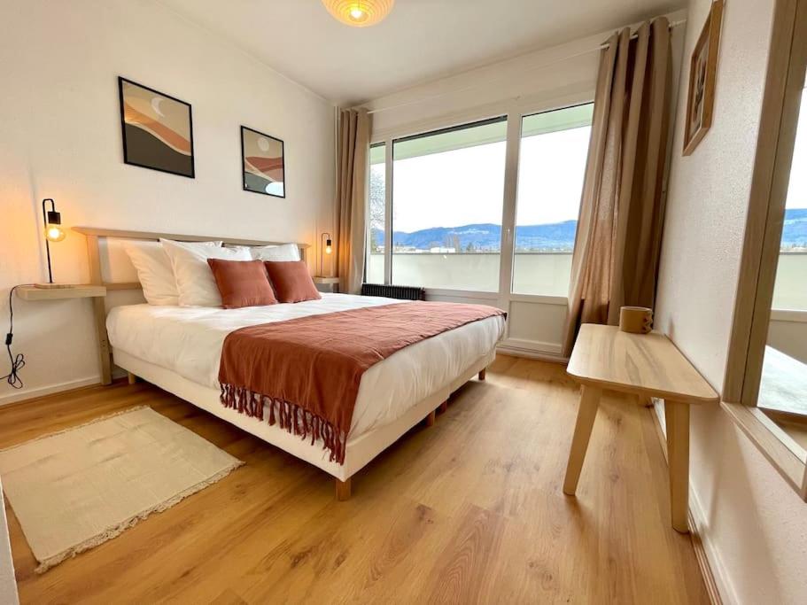 ein Schlafzimmer mit einem großen Bett und einem großen Fenster in der Unterkunft Appartement - Lit Queen Size - Proximité Genève in Saint-Julien-en-Genevois