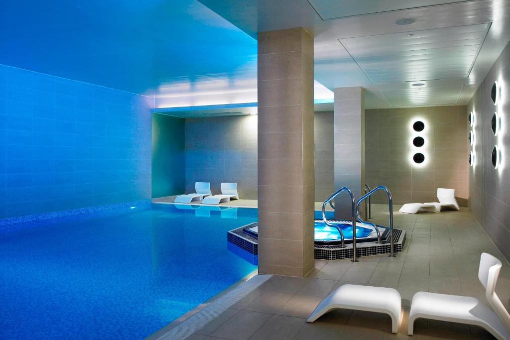 a pool in a hotel room with a swimming pool at Lingfield Park Marriott Hotel & Country Club in Lingfield