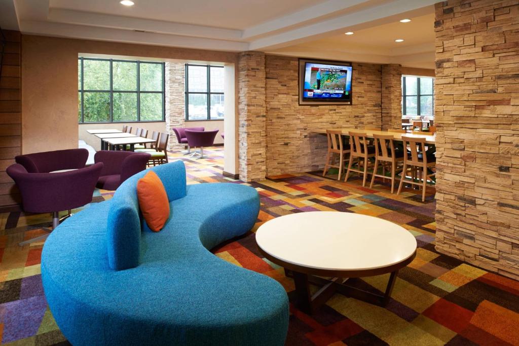 a living room with a blue couch and a tv at Fairfield Inn & Suites Indianapolis East in Indianapolis