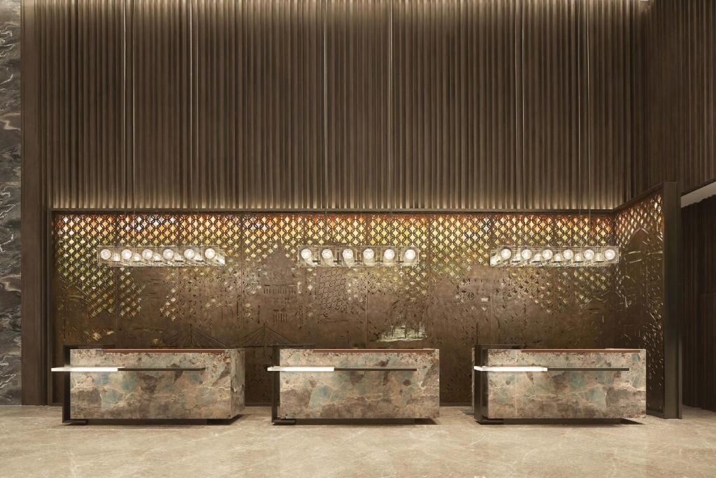 a lobby with four tables and a wall with gold at Four Points by Sheraton Guiyang, Huaxi in Guiyang