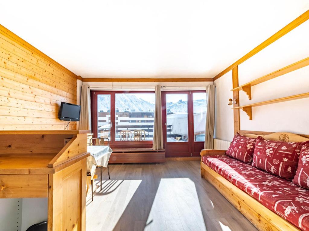 salon z czerwoną kanapą i oknem w obiekcie Studio lumineux avec terrasse, skis aux pieds, Tignes Le Lac - FR-1-502-490 w mieście Tignes