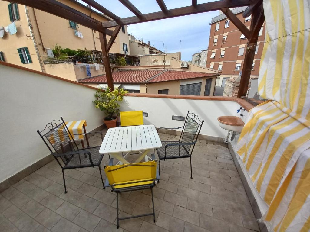 patio ze stołem i krzesłami na balkonie w obiekcie "La Casita", 2 Floors Apartment, Private Parking 1 car OR 2 Bikes, Air-Cond and Terrace w mieście Livorno