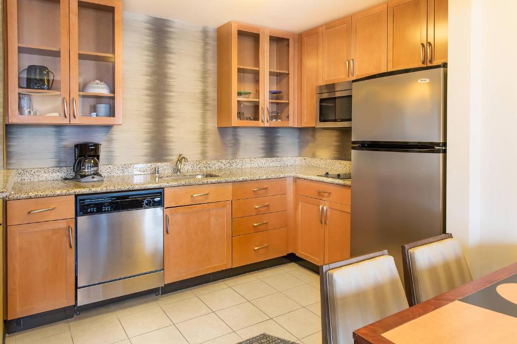 a kitchen with wooden cabinets and stainless steel appliances at Residence Inn Lexington Keeneland/Airport in Lexington