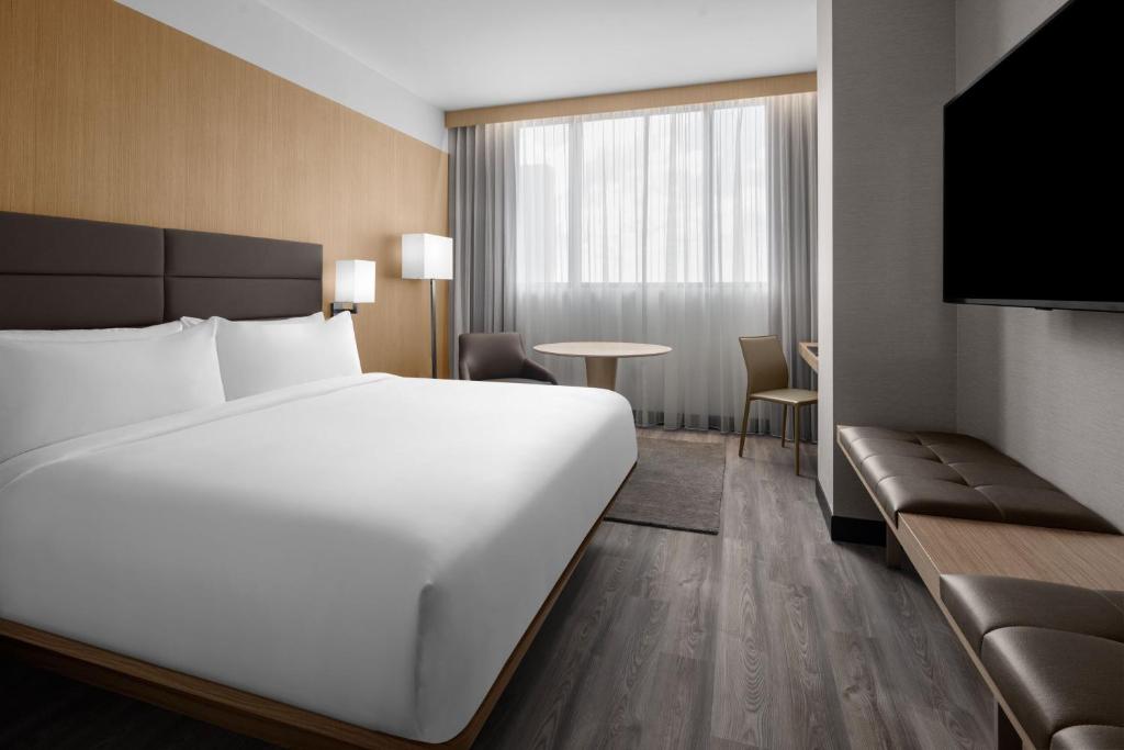 a hotel room with a large white bed and a table at AC Hotel By Marriott Miami Brickell in Miami