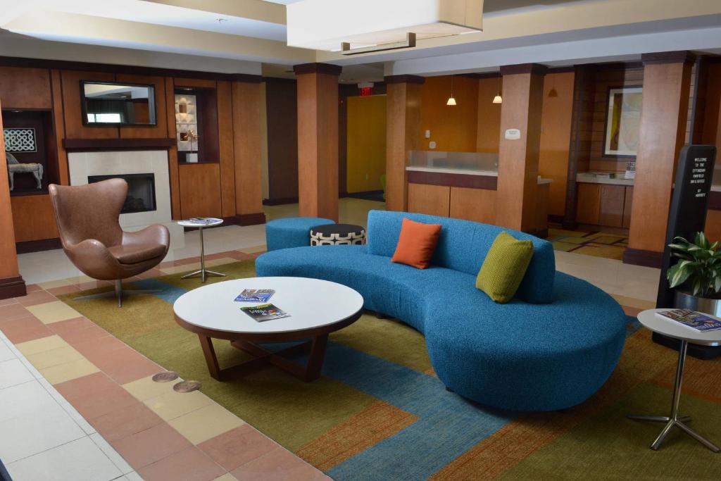 a living room with a blue couch and a table at Fairfield Inn & Suites Effingham in Effingham