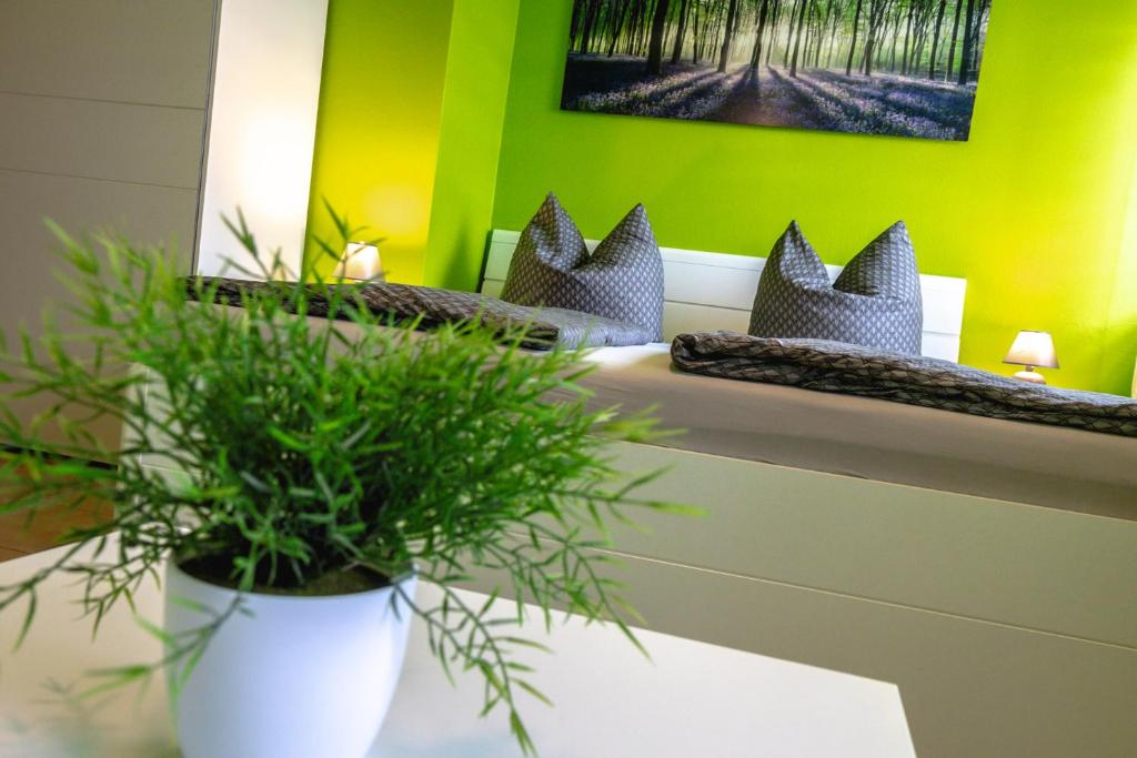Pension Village في ناومبورغ: غرفة مع سريرين مع نباتات الفخار على طاولة