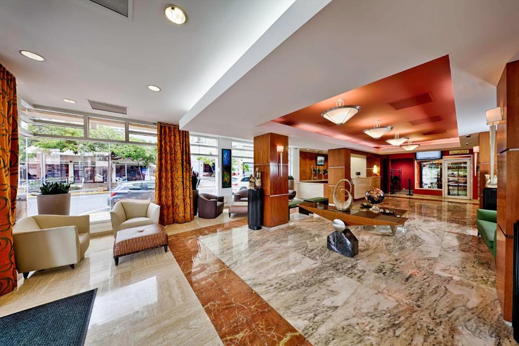 a living room with a couch and a table at Courtyard by Marriott San Juan Miramar in San Juan