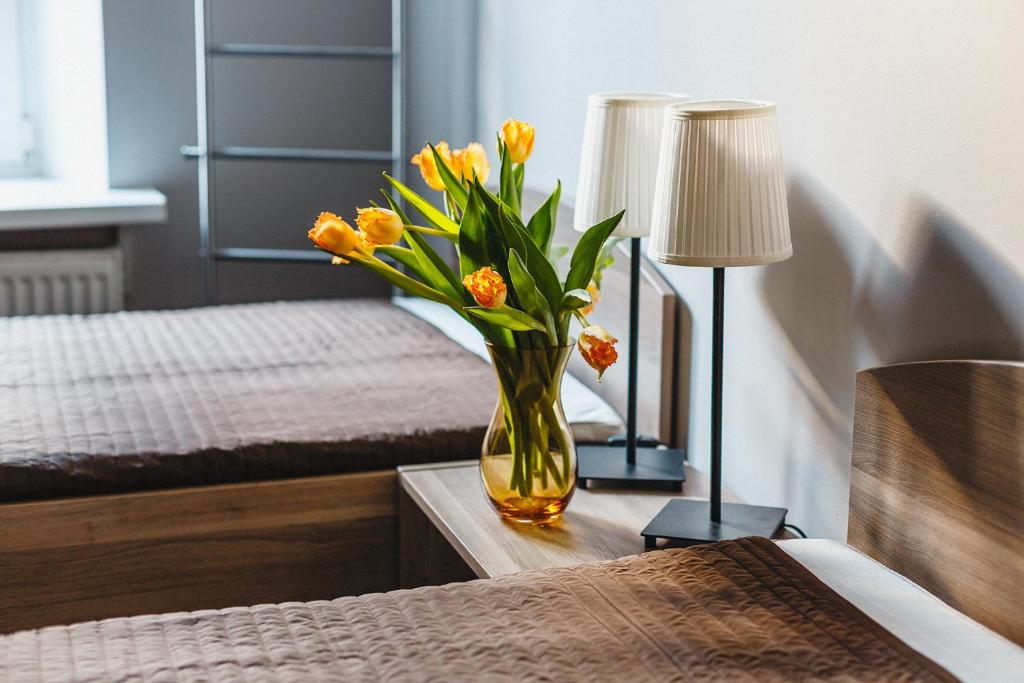wazon kwiatów na stole w sypialni w obiekcie All Dreams Rooms w Petersburgu