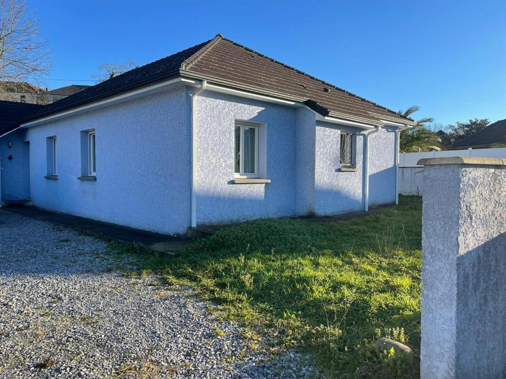 una pequeña casa blanca con un patio de césped en Chambre chez l habitant 2 en Moumour