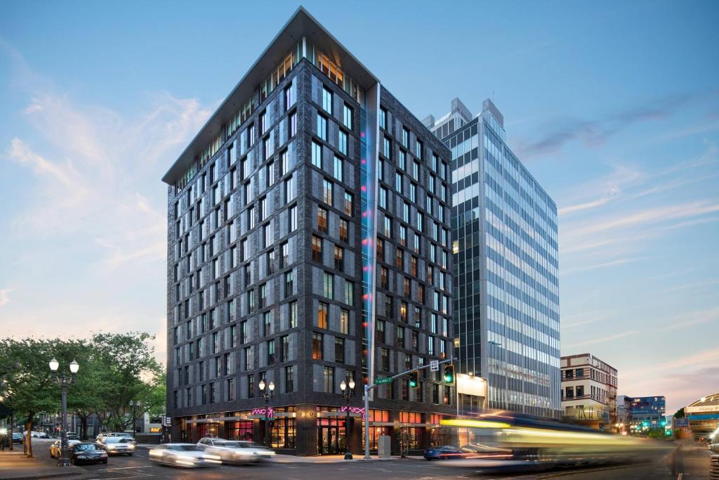 a tall building on a city street with cars at Moxy Portland Downtown in Portland