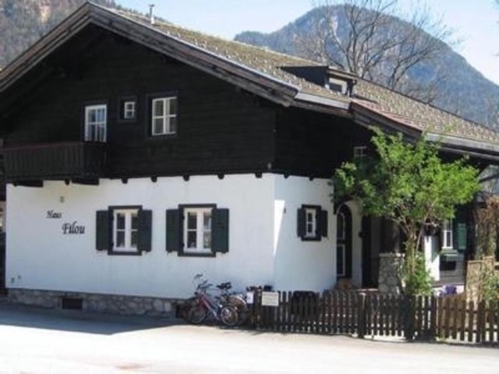 a black and white house with a motorcycle parked in front of it at Gemütliches Ferienhaus in Lofer mit Terrasse, Garten und Grill in Lofer