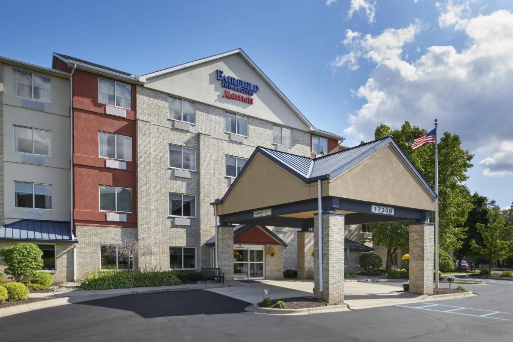 a hotel with an american flag in front of it at Fairfield Inn & Suites Detroit Livonia in Livonia