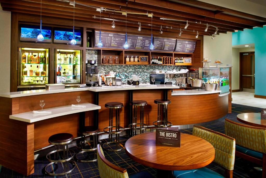 a bar in a restaurant with a table and stools at Courtyard by Marriott Orlando Lake Nona in Orlando
