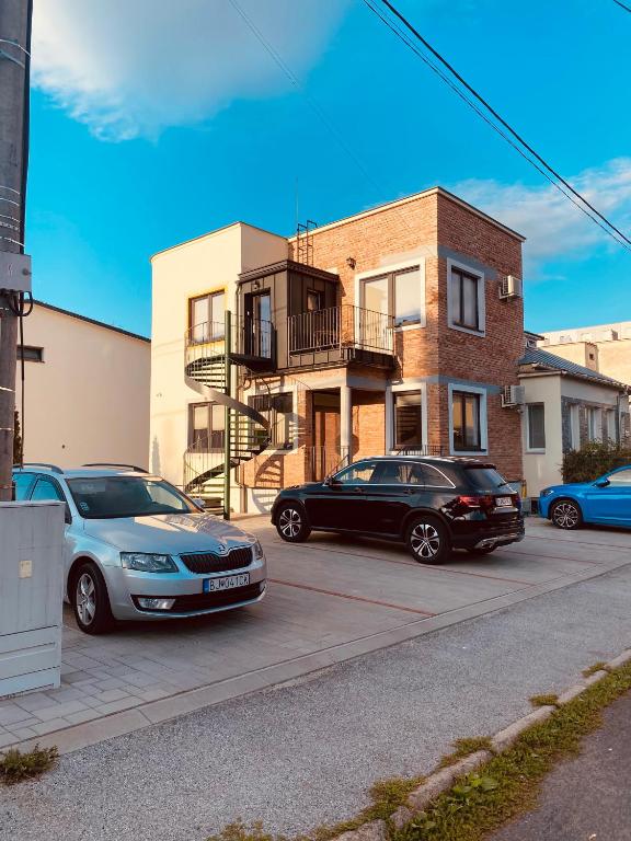 twee auto's geparkeerd op een parkeerplaats voor een gebouw bij Dvojizbový apartmán v blízskom centre Bardejova in Bardejov