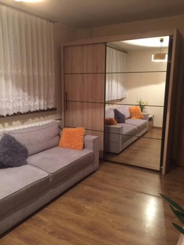 a living room with a couch and a mirror at Mieszkanie Diamentowa in Gdańsk