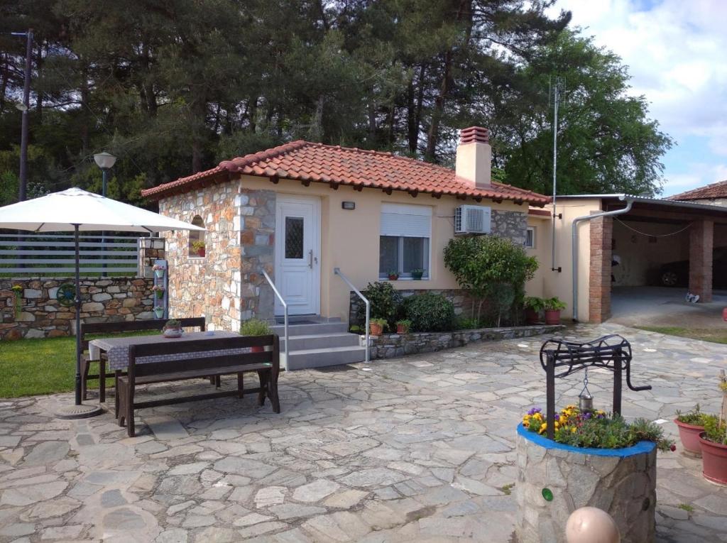 a house with a table and a bench in front of it at AMISIANA LITTLE BEAUTY NEXT TO NATURE in Kavala