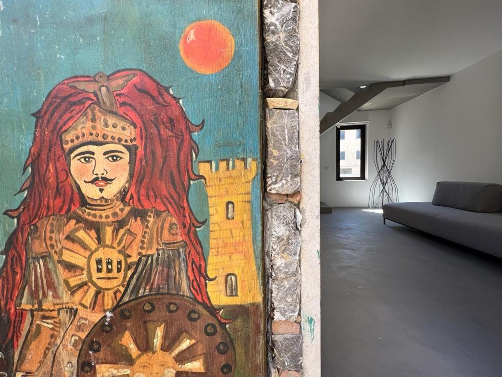 a painting on a wall in a living room at Terme Luxury Suite in Taormina