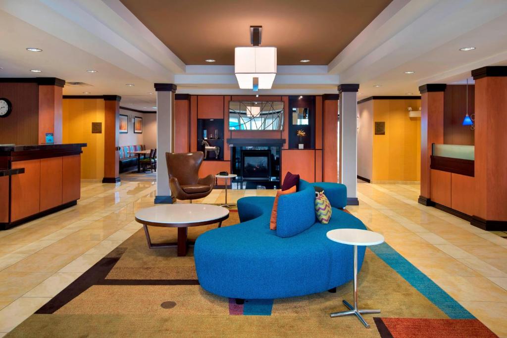 Fairfield Inn & Suites Verona في فيرونا: غرفة معيشة مع أريكة زرقاء وطاولة