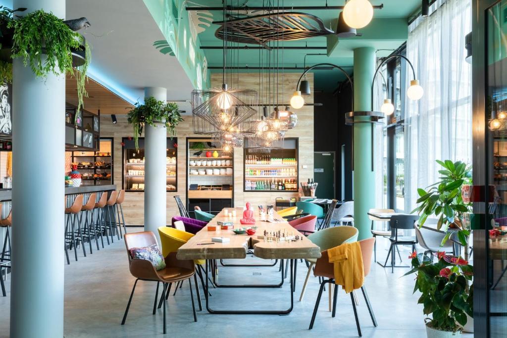 Moxy Paris Val d'Europe في مونتِفري: غرفة طعام مع طاولة وكراسي