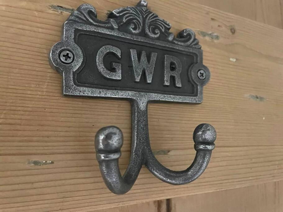 a sign that says give on a wooden door with handcuffs at The Railway Cottage Bridgnorth in Bridgnorth