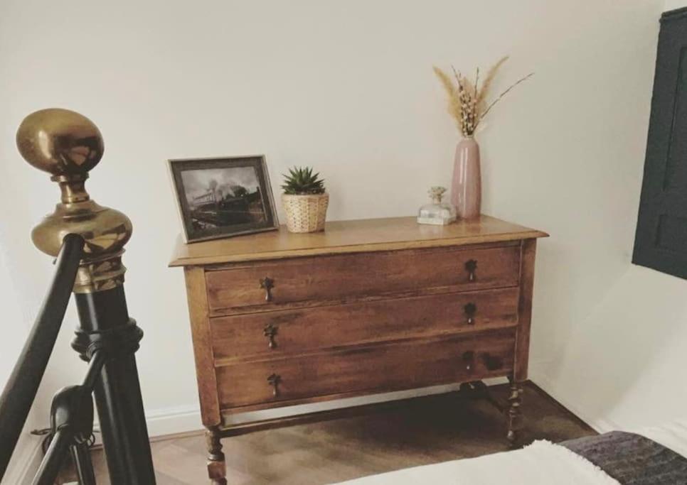 a wooden dresser with a picture on top of it at The Railway Cottage Bridgnorth in Bridgnorth