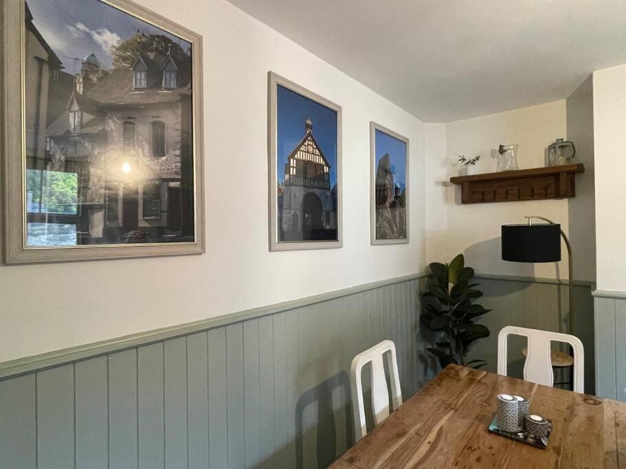 a dining room with a table and some pictures on the wall at The Railway Cottage Bridgnorth in Bridgnorth
