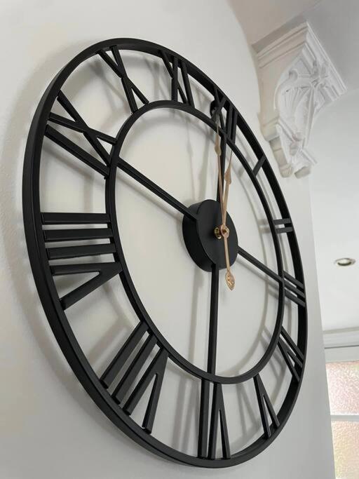 a black and white clock hanging on a wall at The Railway Cottage Bridgnorth in Bridgnorth