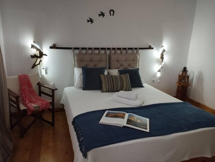 a bedroom with a large bed with a book on it at Plaka Cottage house in Potámion