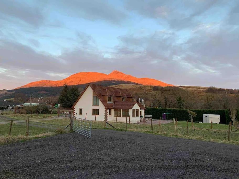 una casa con una montaña en el fondo en Tigh Na Cille Studio, Taynuilt, en Taynuilt