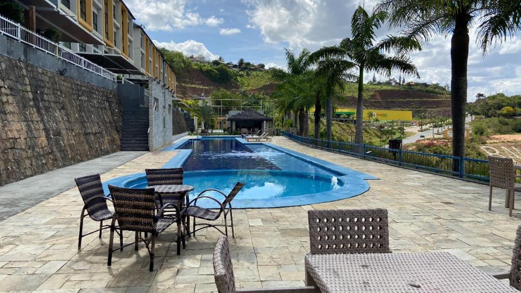 a patio with a table and chairs and a pool at Aluguel em Bananeiras PB in Bananeiras