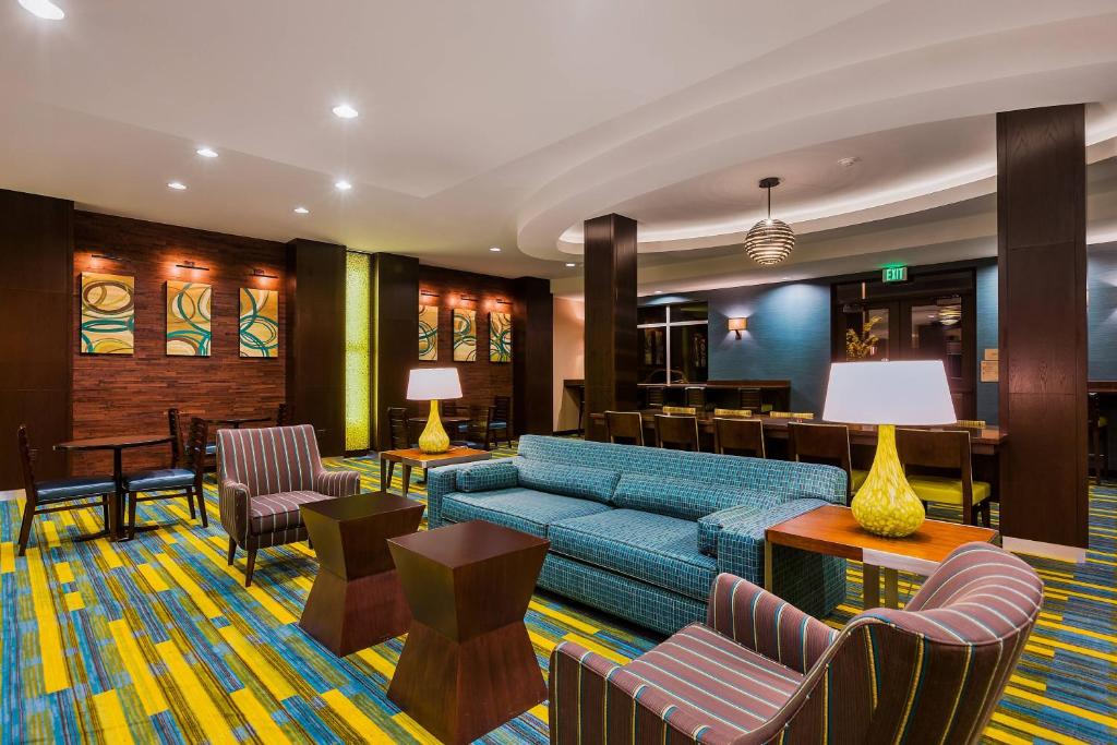 a hotel lobby with a blue couch and chairs at Fairfield Inn & Suites Riverside Corona/Norco in Norco