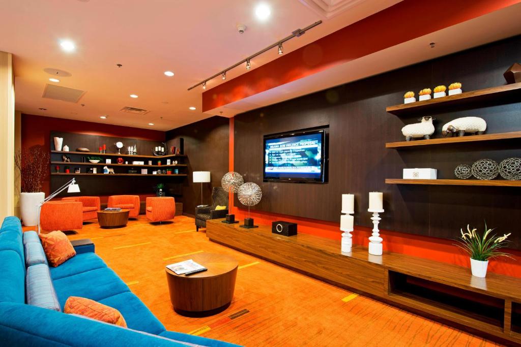 a living room with a blue couch and a television at Courtyard by Marriott Ottawa East in Ottawa