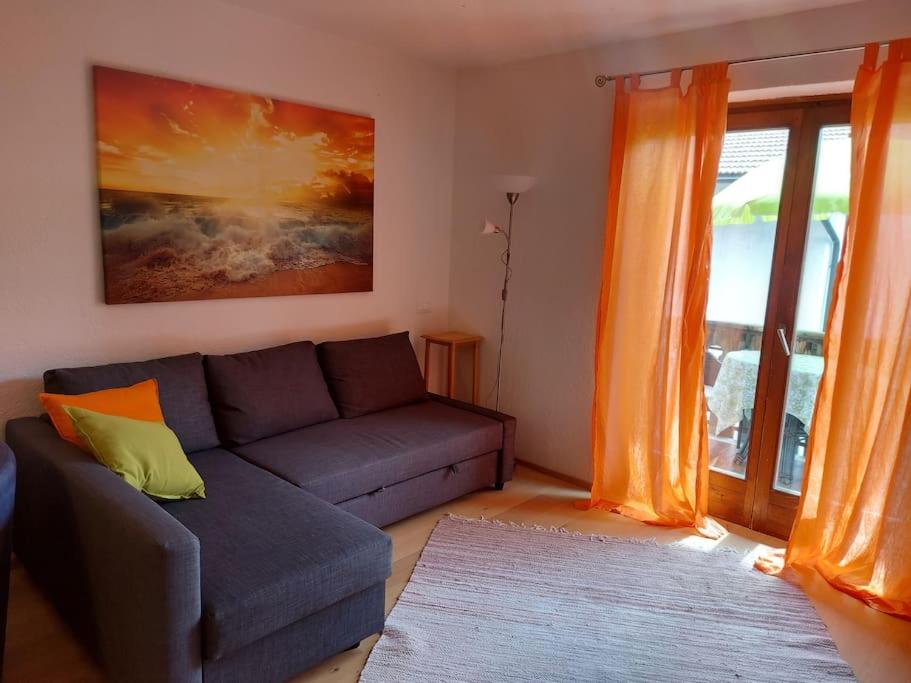 uma sala de estar com um sofá e uma janela em Apartment Sonne auf Bio-Hof em Merano