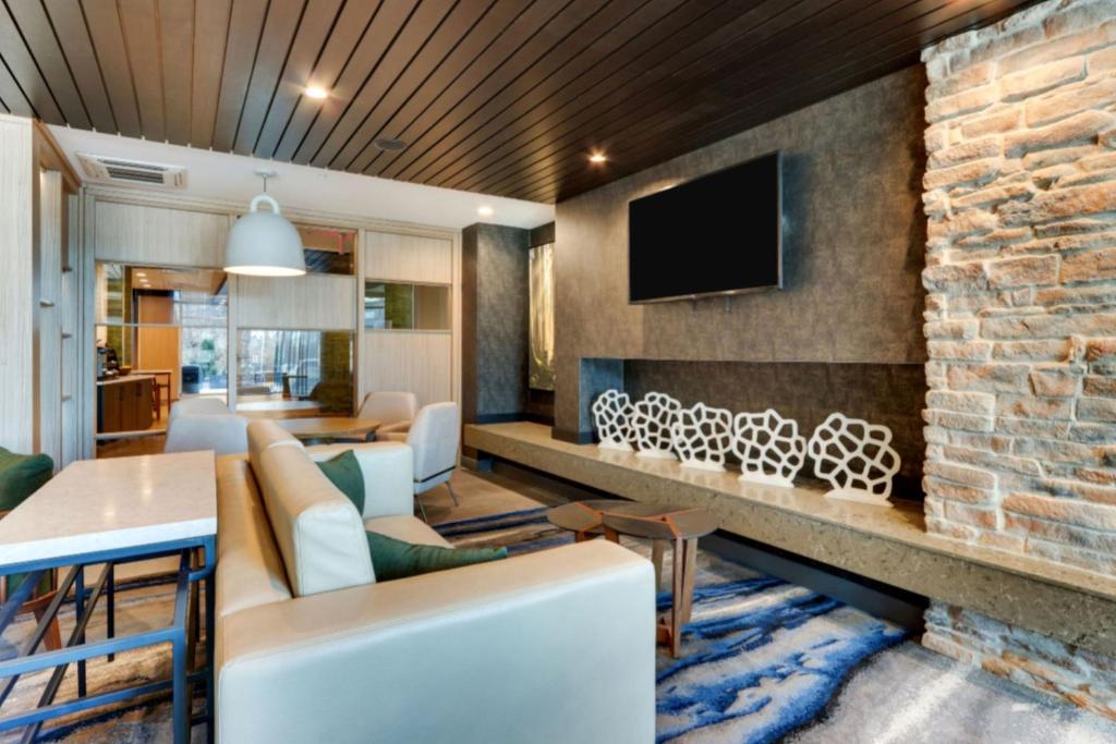 un soggiorno con parete in mattoni e TV di Fairfield by Marriott Inn & Suites Dalton a Dalton