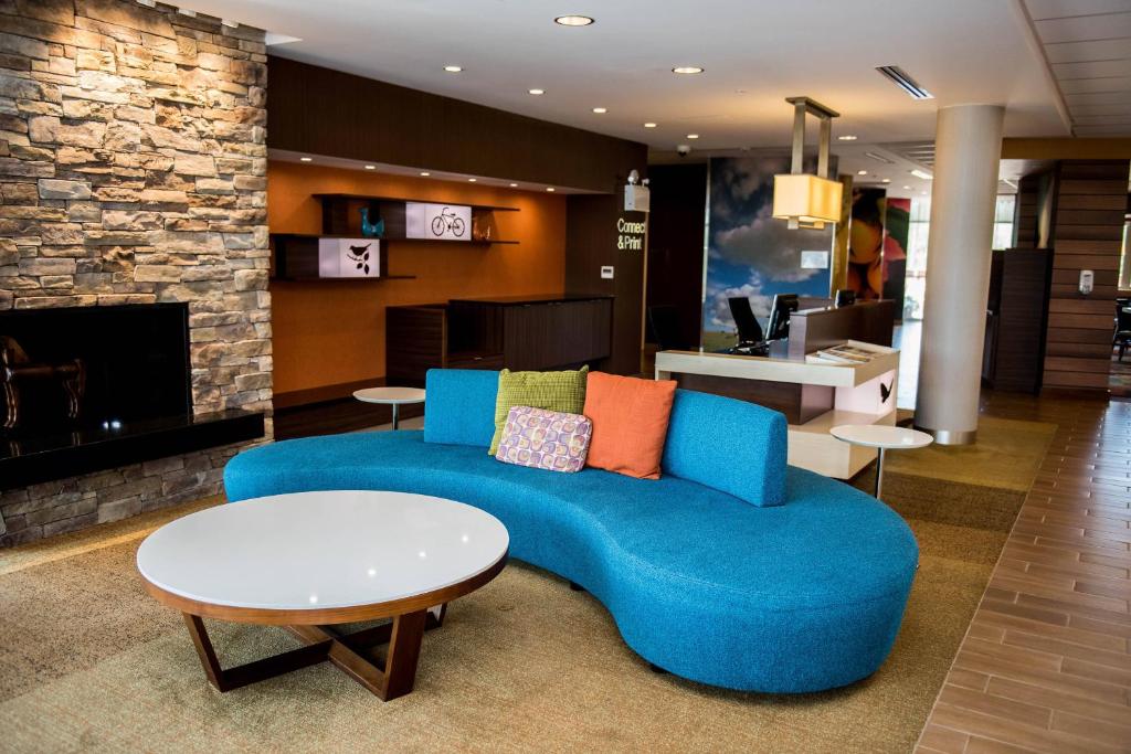 a living room with a blue couch and a fireplace at Fairfield Inn & Suites by Marriott Moncton in Moncton