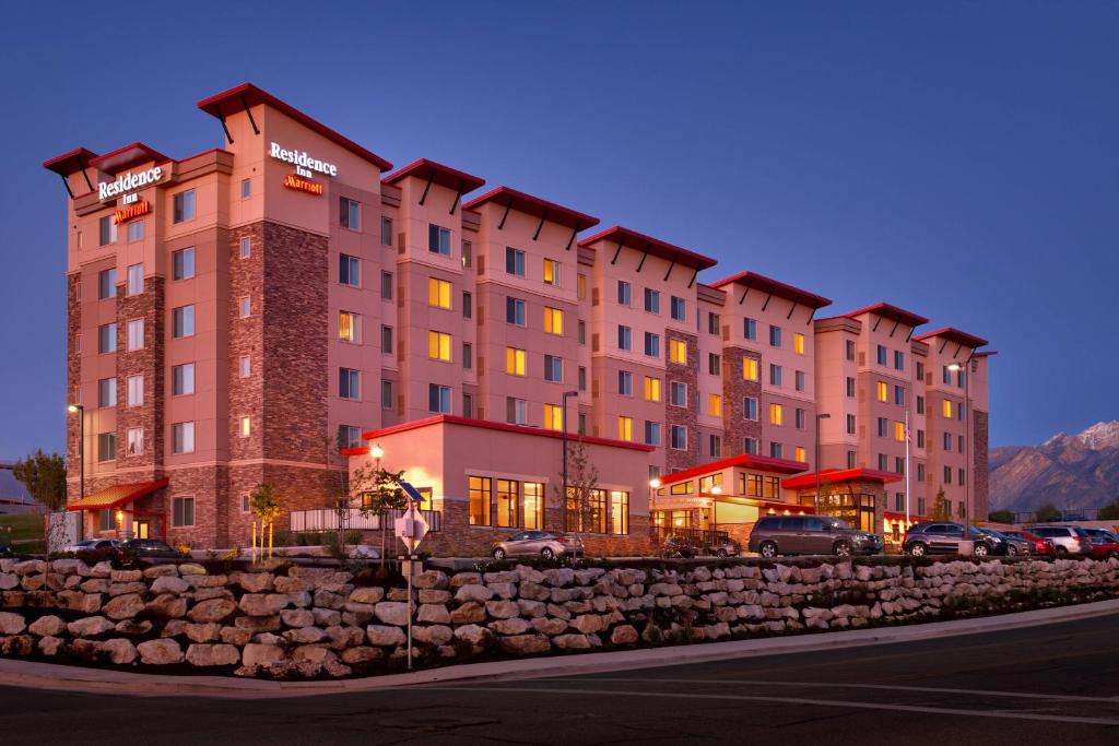 a large building with cars parked in front of it at Residence Inn Salt Lake City Murray in Murray