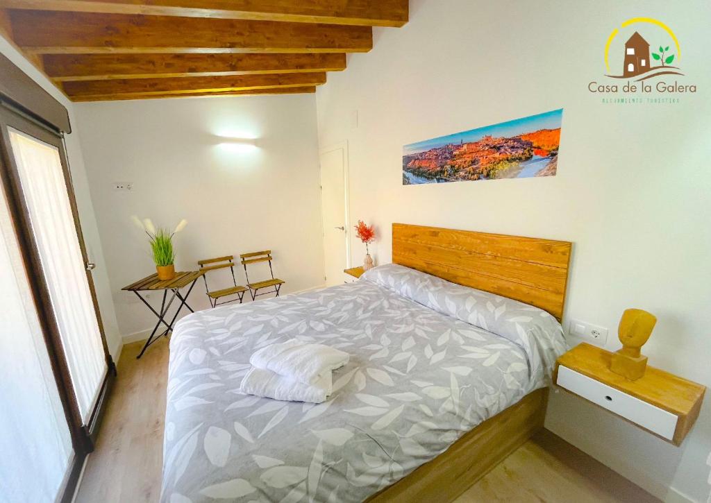 a bedroom with a bed with a wooden head board at Casa de la GALERA in Toledo