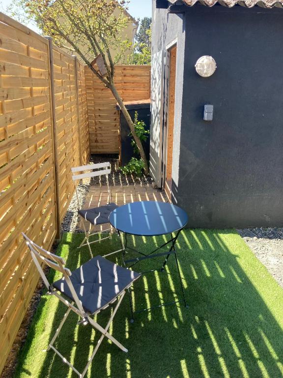 une cour avec deux chaises et une clôture dans l'établissement Studio avec terrasse et parking au Mans, au Mans