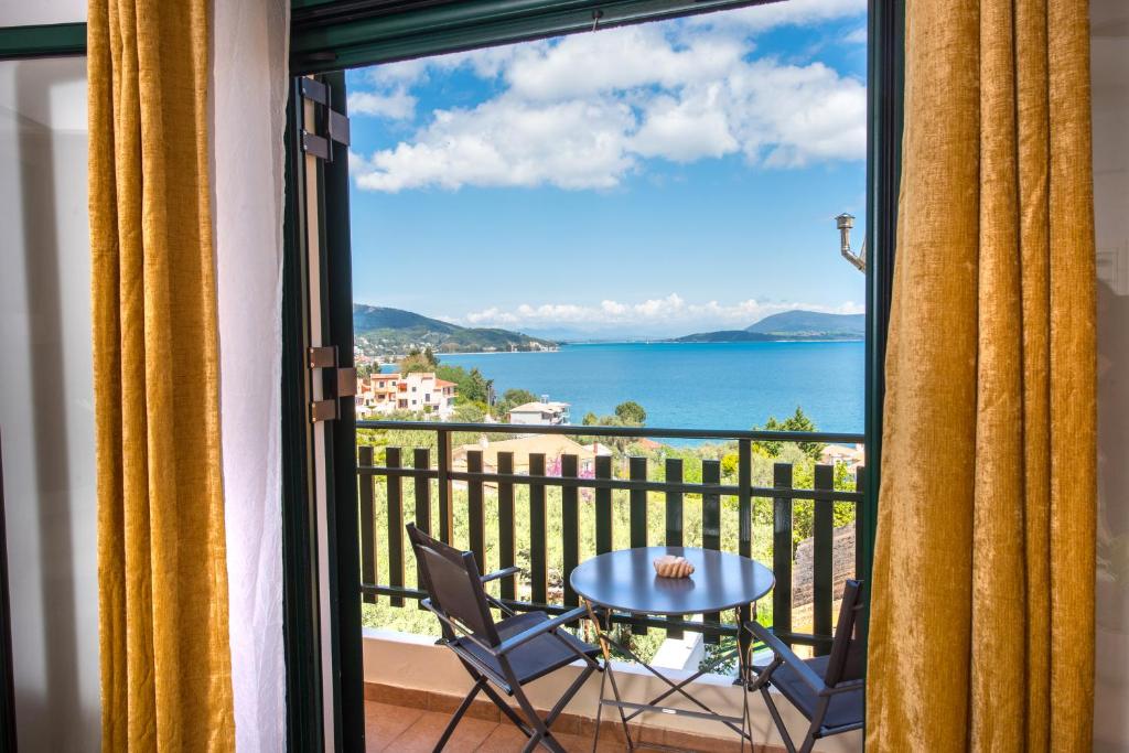 a balcony with a table and chairs and a view of the ocean at Amelia Villa in Nikiana