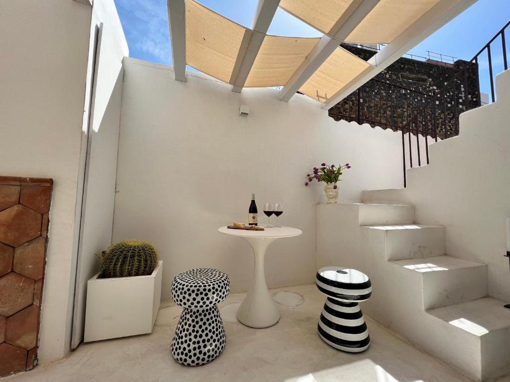 a room with a table and chairs and stairs at Terme Luxury Suite in Taormina